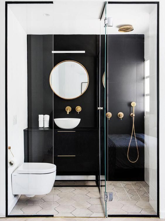 banheiro pequeno com paredes pretas e porcelanato hexagonal cinza. Metais dourados