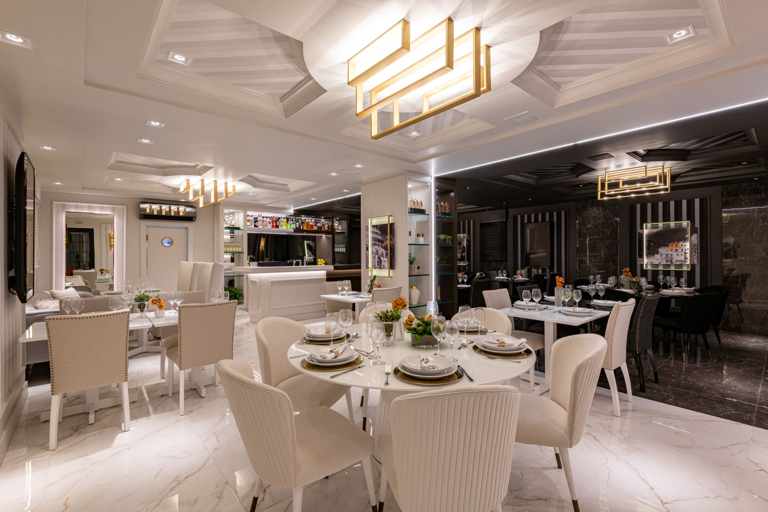 Restaurante Limone, CASACOR São Paulo 2019, Habitat Projetos Inteligentes. Restaurante com conceito de dualidade. "Lado dia", porcelanato que imita mármore branco, cadeiras clássicas brancas, mesas de mármore branco e teto de gesso.