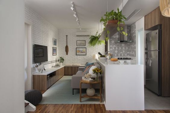 Sala pequena integrada com cozinha, com tijolinho branco,azulejo geométrico,plantas e sofá cinza