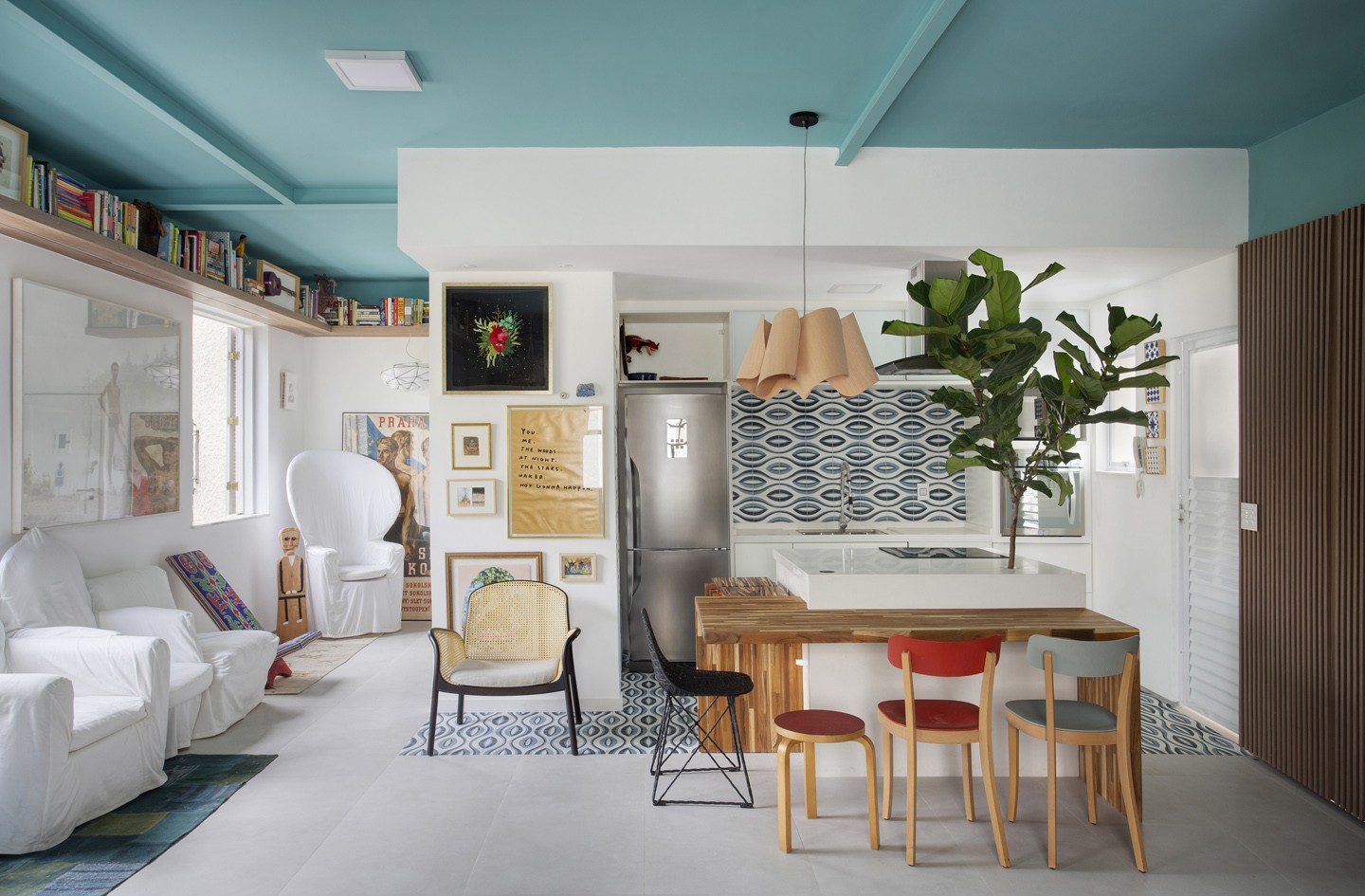 Cozinha branca com, cadeiras coloridas, planta e Ladrilho Hidráulico