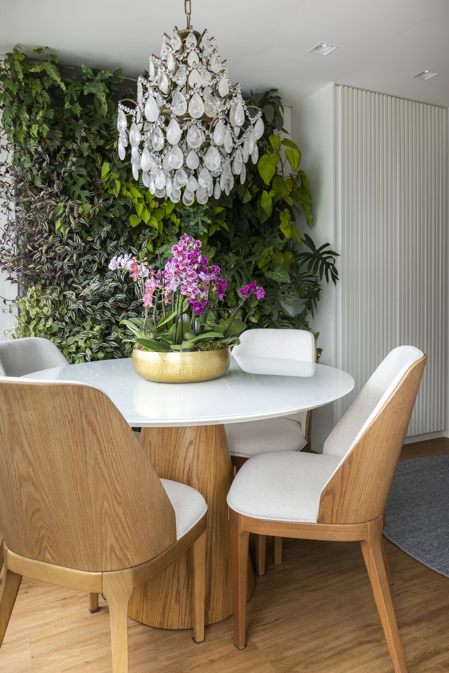 Ambiente com lustre, mesa branca com cadeira e piso vinilico