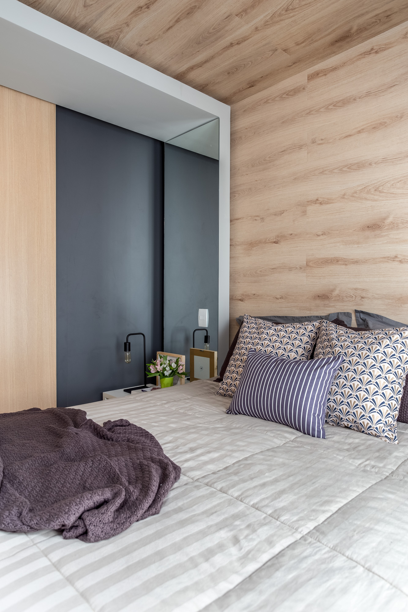 quarto de casal com parede de drywall revestida com piso vinílico aplicado na cabeceira do quarto, parede da cama  e no teto