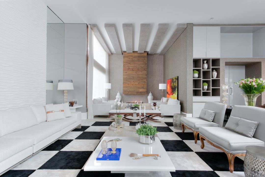 Projeto de 800m² - Arquiteto Erique Moreira: área social com tapete tabuleiro que se destaca por estar localizado próximo ao jantar, sofá branco e almofadas cinzas e mesinha de centro branca.