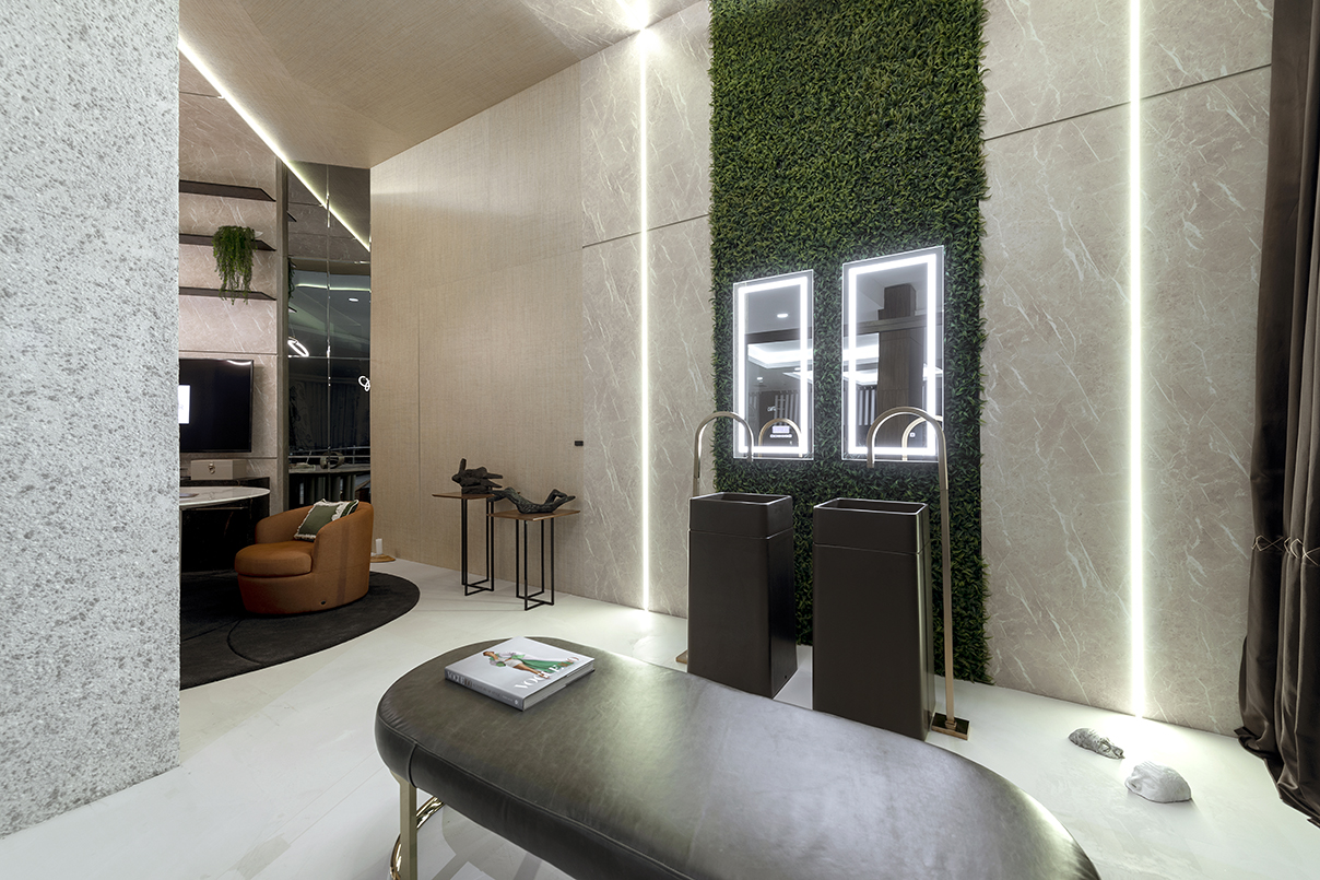 Janelas CASACOR - Ambiente com piso porcelanato branco, banco estofado de couro preto, revestimento de porcelanato na parede com jardim vertical.