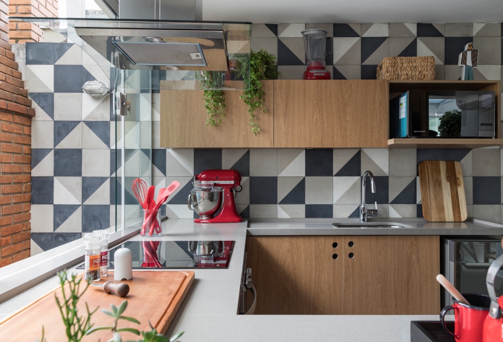 Cozinha com azulejo em tons de cinza, armário amadeirado, bancada cinza e eletrodomésticos vermelhos