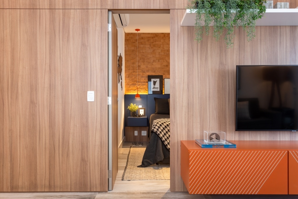 O painel de madeira, com a porta mimetizada, resguarda a entrada para o dormitório do morador 