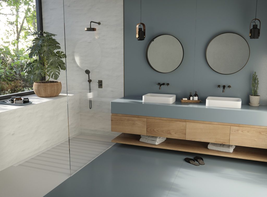 Banheiro moderno, com área do box de vidro com revestimento branco, demais área com revestimento azul no piso e parede, superfície da bancada Silestone® Cala Blue 