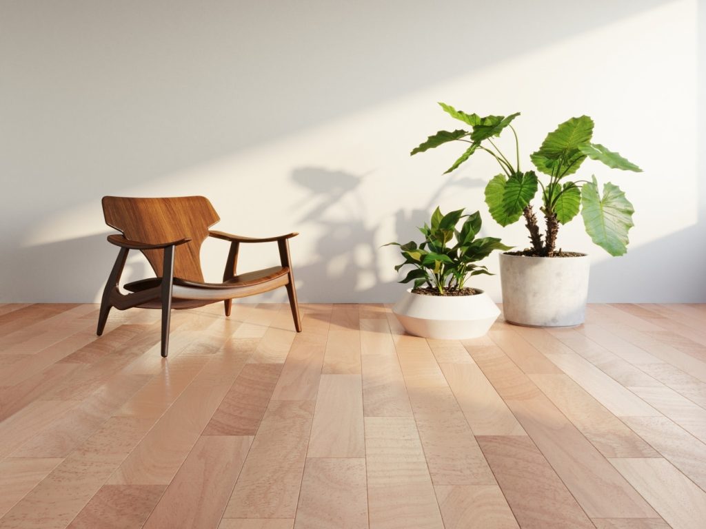 Ambiente minimalismo com piso Tauri Caramel em tom claro, cadeira de madeira, vasos de plantas branco e parede branca