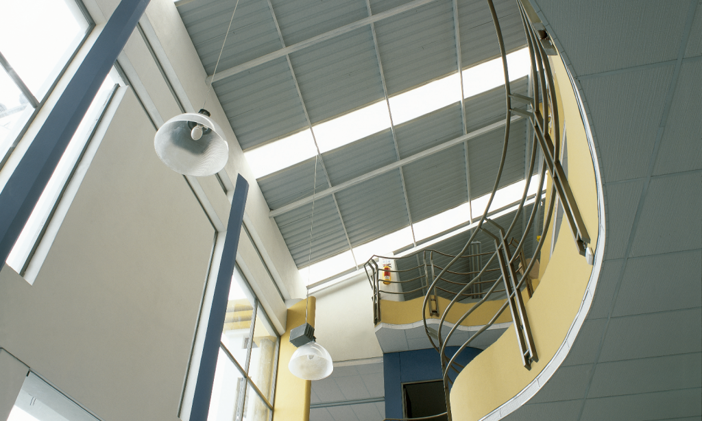Ambiente empresarial com escadas e telha de policarbonato