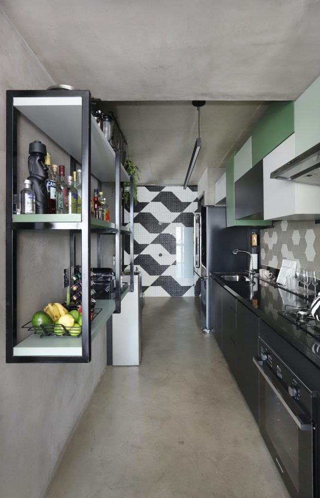 Cozinha estilo industrial com piso, parede e teto de cimento queimado, frontão da pia com ladrilhos verde e branco, armários superiores verde e brancos, e demais decoração em preto e branco