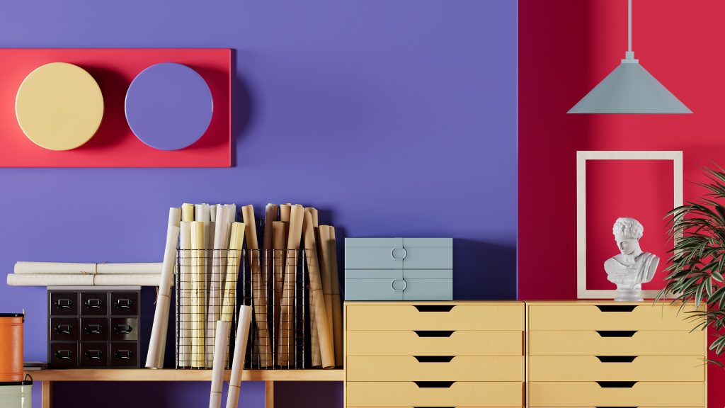 Cantinho de home office com a cor do ano 2022 e vermelho, papéis, gavetas e objetos decorativos